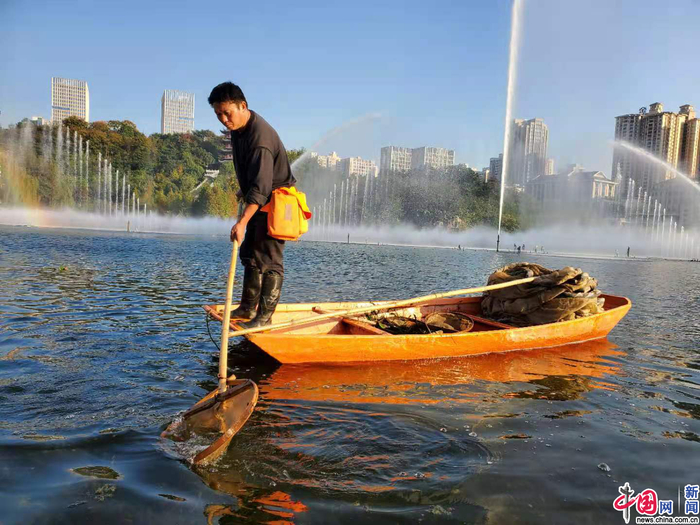 永川兴龙湖公园，工人正在捞起水中杂物。 （中国网记者 严星/摄）