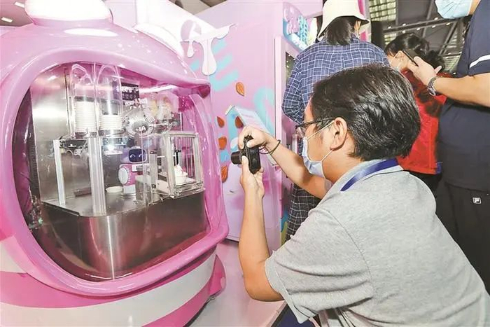 ▲市民体验购买由机器人制作的冰淇淋。