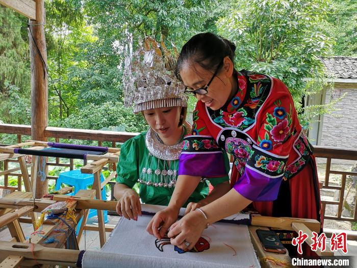 重庆市非物质文化遗产“彭水苗绣”代表性传承人李绍玉讲解苗绣技艺。王光荣 供图