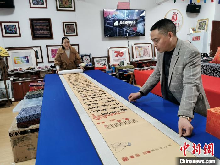 李绍玉和王光荣展示“苗绣”工艺。　张燕 摄