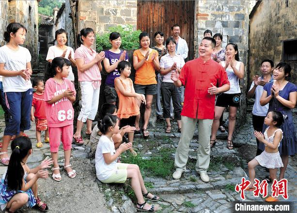 大陈村党总支书记汪衍君与村民们一起唱歌。　衢州市委统战部 供图