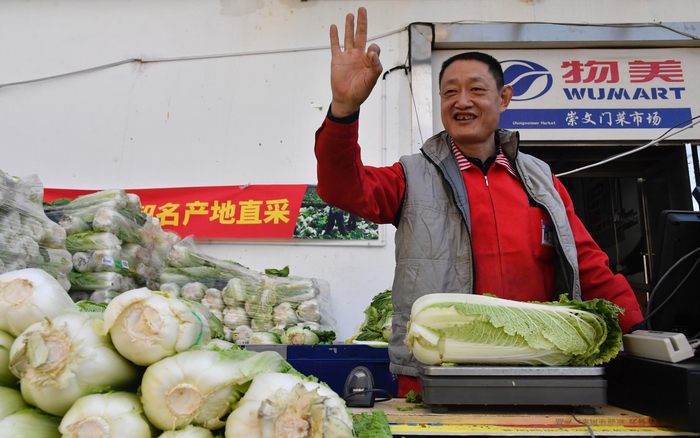 售货员在为顾客购买的大白菜称重，这颗3公斤左右的大白菜2.3元。&nbsp;新京报记者&nbsp;吴宁&nbsp;摄