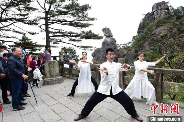 图为太极爱好者在三清山女神峰前打太极。 胡敦煌 摄
