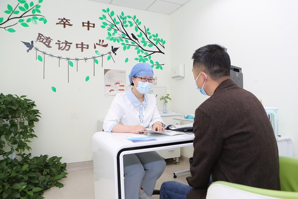 图说：个案管理师王文协在随访门诊接待患者 摄影/石庆（下同）