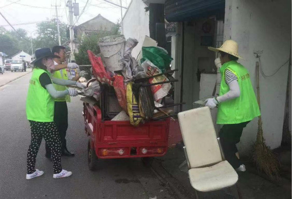 图说：志愿者清理社区垃圾。崇明区新闻办供图（下同）