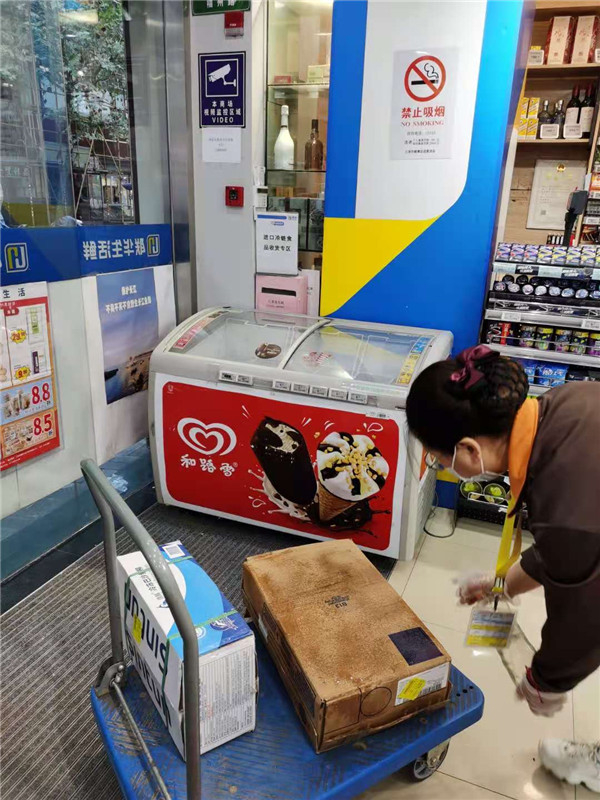 图说：赵琴珍对着进口巴沙鱼外包装箱的表面喷洒消毒 来源/采访对象提供