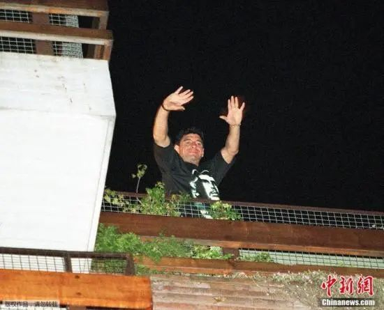 资料图：1997年10月30日晚，马拉多纳在布宜诺斯艾利斯公寓的阳台上向球迷和记者挥手致意。此前他在接受一个电视节目的电话采访时宣布退役。