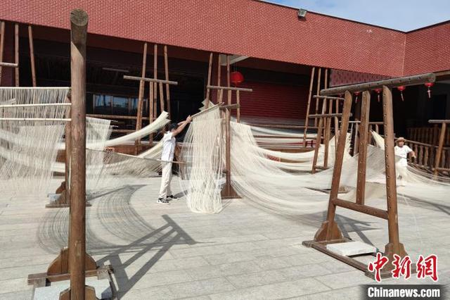 传统手工艺人在户外制作、晾晒手工面线。 吴冠标 摄