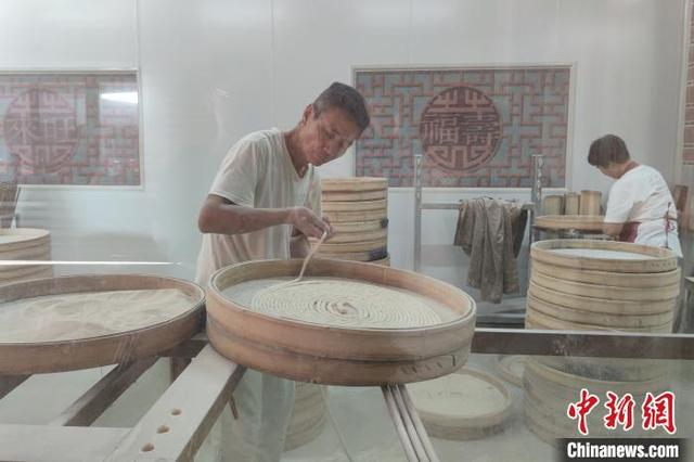 在来旺良品堂闽南古早味传承基地，游客透过透明的橱窗，可以观看手工面线等美食的制作流程。 吴冠标 摄