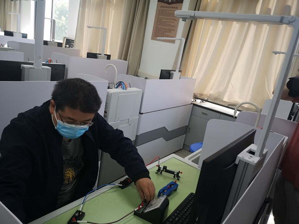 图说：工作人员演示物理实验测评赋分方式 