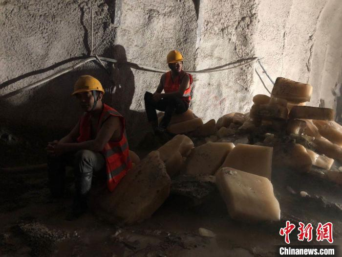 图为隧道平导掘进面施工工人坐在冰块堆上休息。　缪超 摄