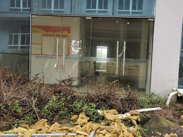 位于铜仁高新区智能终端产业园的贵州长瑞科技办公楼闲置已久，荒草丛生。摄影/本报记者 张家振