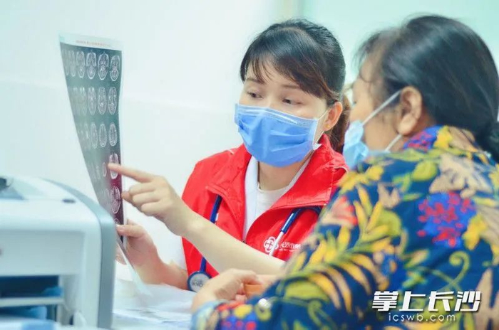 眩晕诊疗中心副主任医师余孝君（左）向患者解释相关检查结果。 医院供图