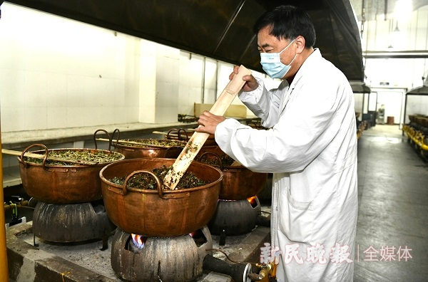图说：膏方制作室里，四十年工龄的老药师陈伟明，正在用竹搅片翻着紫铜锅里的药材 新民晚报记者 徐程 摄（下同）