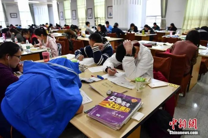 资料图：学生在图书馆自习室内写作业。中新社记者 任东 摄