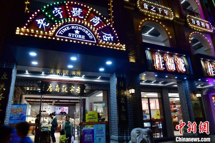 图为11月8日晚，市民和游客在街区老字号商店购买商品。　张斌 摄