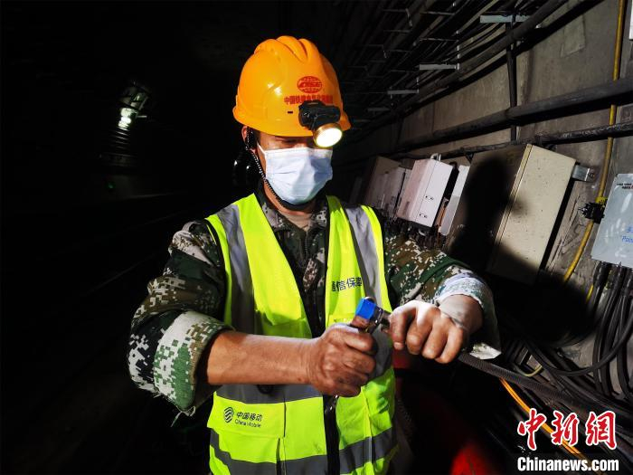 网络施工人员挑灯铺设地铁隧道5G信号 王政 摄