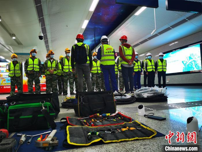 网络施工人员挑灯铺设地铁隧道5G信号 王政 摄