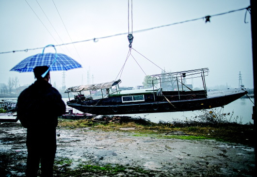 ▲在长江新螺段白鱀豚国家级自然保护区渔船拆解现场，一名渔民注视着渔船的拆解工作（2019年12月25日摄）。新华社记者肖艺九摄