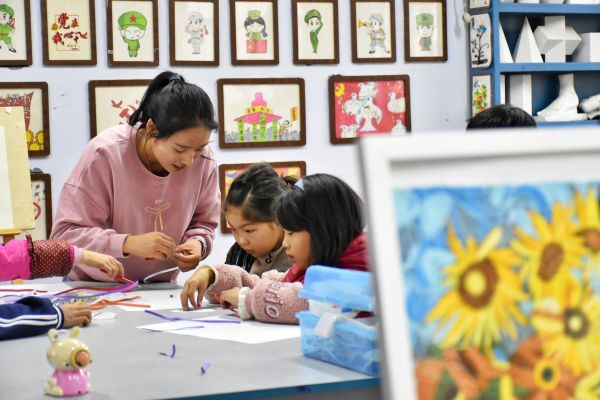 改善农村教育对中国至关重要。图为11月18日，23岁的河南省嵩县德亭镇酒店小学全科教师王予川在教学生制作衍纸。（韩朝阳 摄）