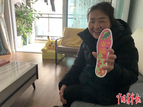     谭道必在女儿家中展示自己绣的鞋垫。中青报·中青网记者 杨杰/摄