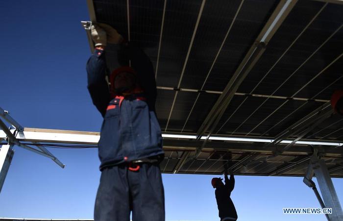 Workers install a solar power unit at the construction site of a 300-MW photovoltaic electricity project of the China Datang Corporation Ltd. in Gonghe County, Tibetan Autonomous Prefecture of Hainan in northwest China's Qinghai Province, Dec. 15, 2020. (Xinhua/Zhang Hongxiang)