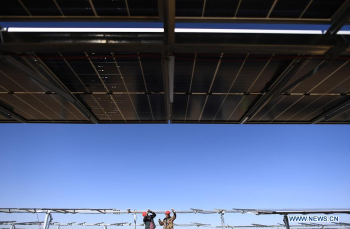 Workers install a solar power unit at the construction site of a 300-MW photovoltaic electricity project of the China Datang Corporation Ltd. in Gonghe County, Tibetan Autonomous Prefecture of Hainan in northwest China's Qinghai Province, Dec. 15, 2020. (Xinhua/Zhang Hongxiang)