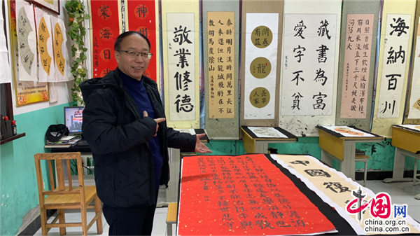 书法老师王秋军介绍学生书法作品。中国网记者 郭泽涵 摄