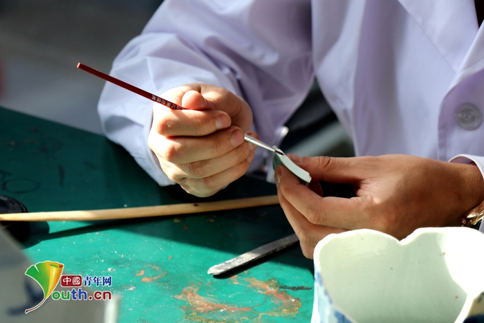 　　修复中心陶瓷修复师正在修复一件瓷器。中国青年网记者姜文山 摄