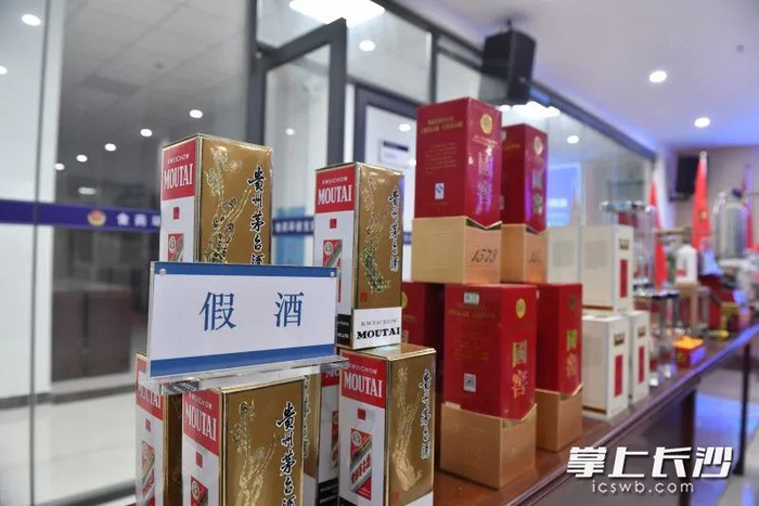 长沙警方展示的部分涉案物品，其中有不少冒充多类品牌的假酒。长沙晚报全媒体记者 邹麟 摄