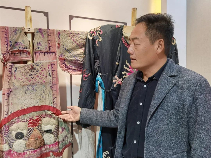 △//于亮兴向我们介绍纯手工缝制的戏服