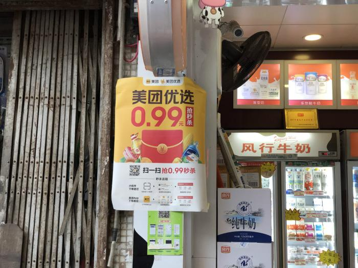 广州市某社区商铺张贴着“美团优选”广告。（黄婉仪/摄）