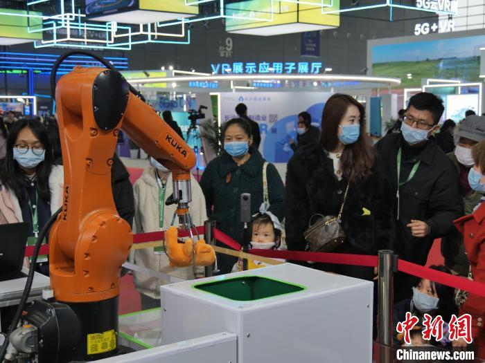 工业机械臂抓娃娃吸引民众驻足观看。　王昊昊 摄