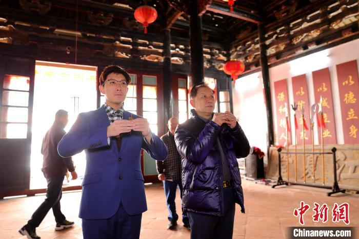 图为台湾青年黄伟伦与其父亲黄毓勉在江夏堂谒祖敬香。　李思源 摄