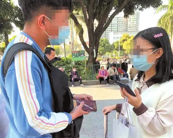 自称是正在实习的大学生拦下一名拉着行李箱的女孩推销笔。见习记者陈来摄