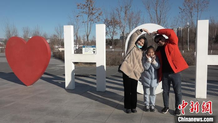 图为台胞郑景文一家三口在“我爱呼和浩特”造型雕塑前合影。　马知远 摄