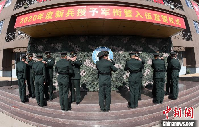 新兵团领导为新兵代表佩戴军衔。　姚富祥 摄