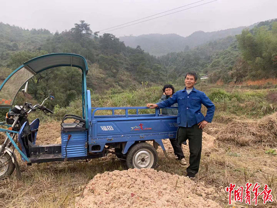范家发骑三轮车上山干活。