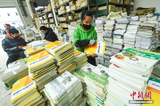 资料图：中小学生发放新学期的教材和教辅材料。 中新社记者 武俊杰 摄