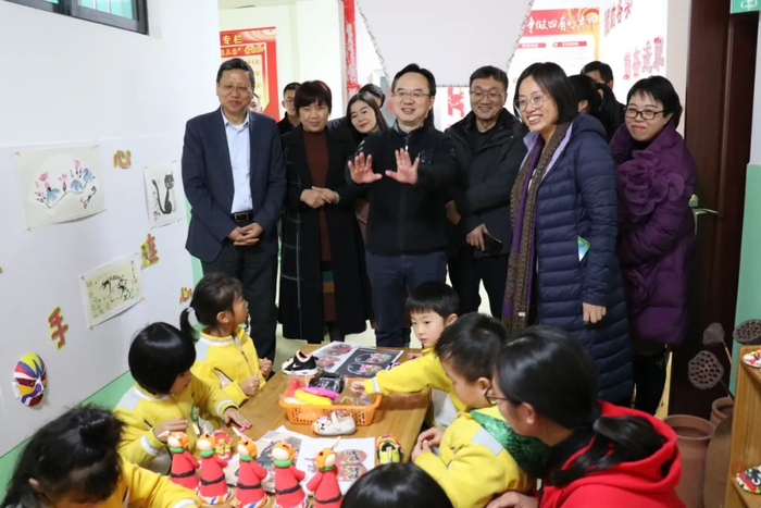 图为何剑波与镇雄县幼儿园的幼儿们互动交流
