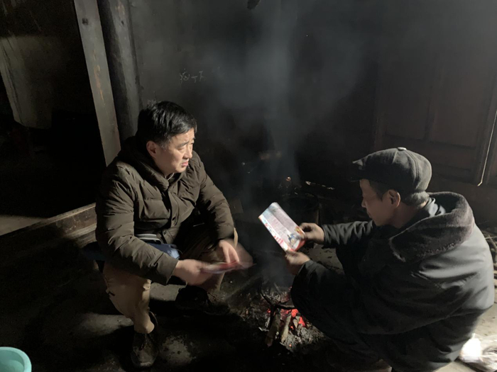 图为熊伟著向贫困户宣传大病医保政策