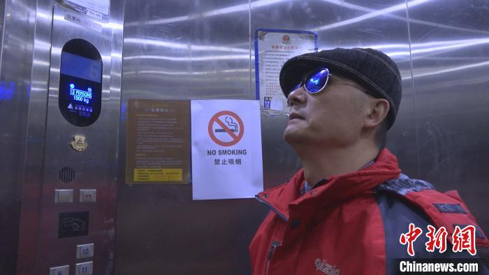 盲人马先生乘坐安装好语音播报器的电梯 康玉湛 摄