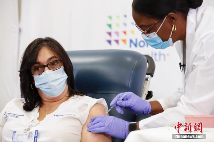 资料图：当地时间12月14日，纽约长岛犹太医疗中心护士史蒂芬妮接种新冠疫苗。 中新社记者 廖攀 摄