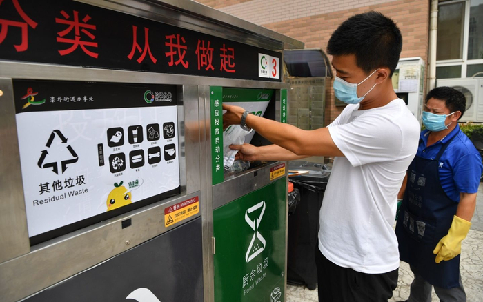 7月30日，东城区新世界家园，居民将一袋厨余垃圾投入装有破袋器的垃圾桶。破袋器会打破塑料袋，倾倒垃圾，再将塑料袋转入其他垃圾桶。摄影/新京报记者 吴江