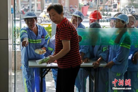 资料图：减少食品的浪费现象，上海民众在食物银行领取超市余量食物。殷立勤 摄