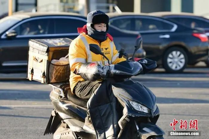 资料图：12月7日，北京，快递小哥“全副武装”出行。中新社记者 田雨昊 摄