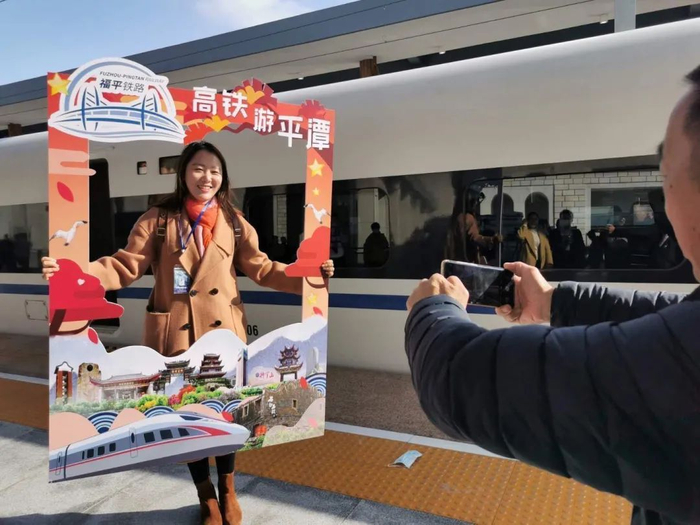 旅客在行前与首发列车合影。刘晓宇 摄