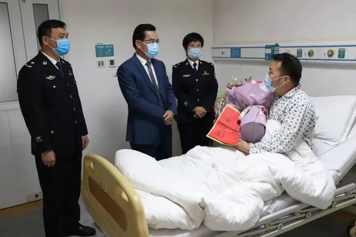 ▲相关负责人看望慰问负伤民警李永飞