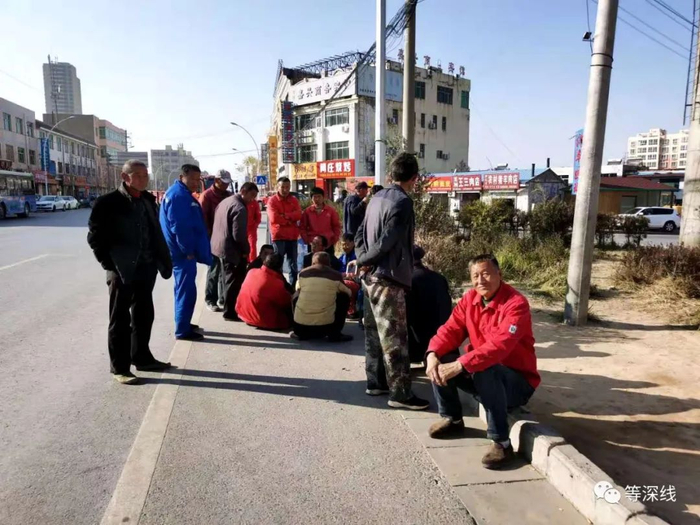 在公路转盘处等待干活的农民工。《等深线》记者 倪兆中 摄