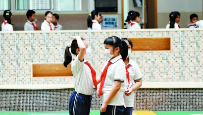 图说：5月18日，长宁实验小学两位女生返校复学首日见面，发现彼此都长高了不少